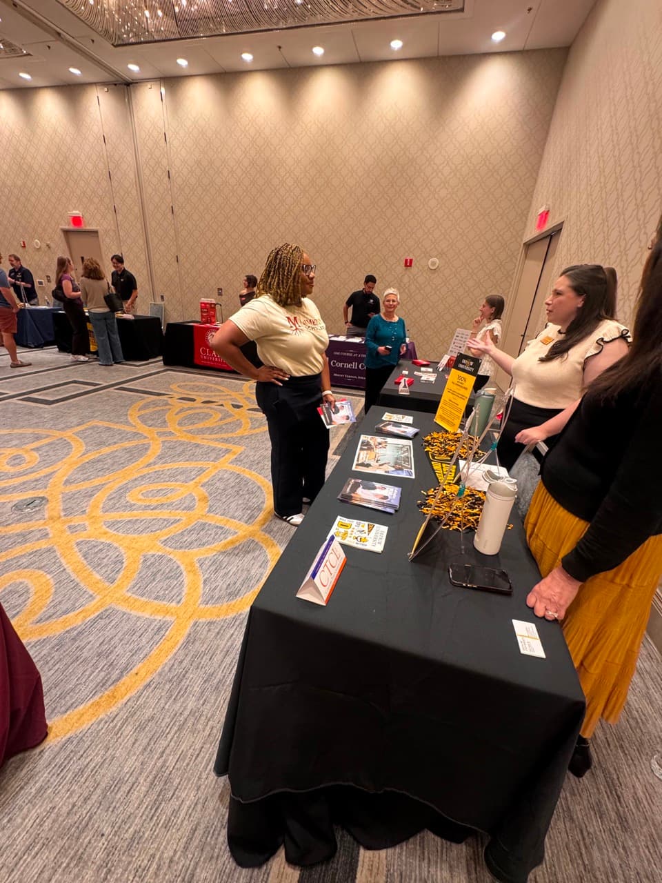 Mmeri Scholars representative talking with university staff at a college fair