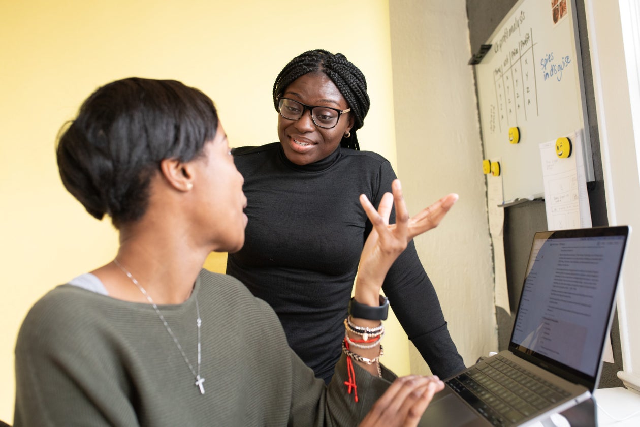 Mmeri advisor talking a scholar through her application on a laptop